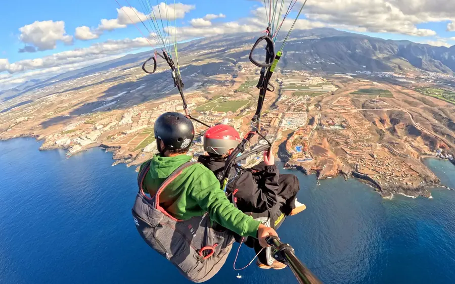 Vistos de trás o piloto e o passageiro, a olhar para toda a costa sul e o mar